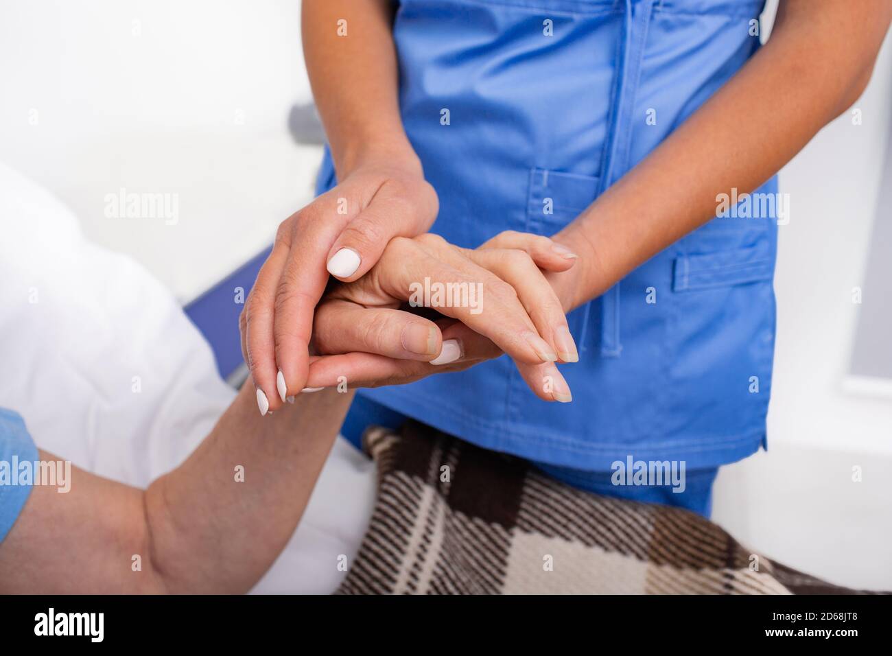 Morbo di Parkinson, il medico tiene la mano della donna anziana. Cura delle persone affette da morbo di Parkinson Foto Stock
