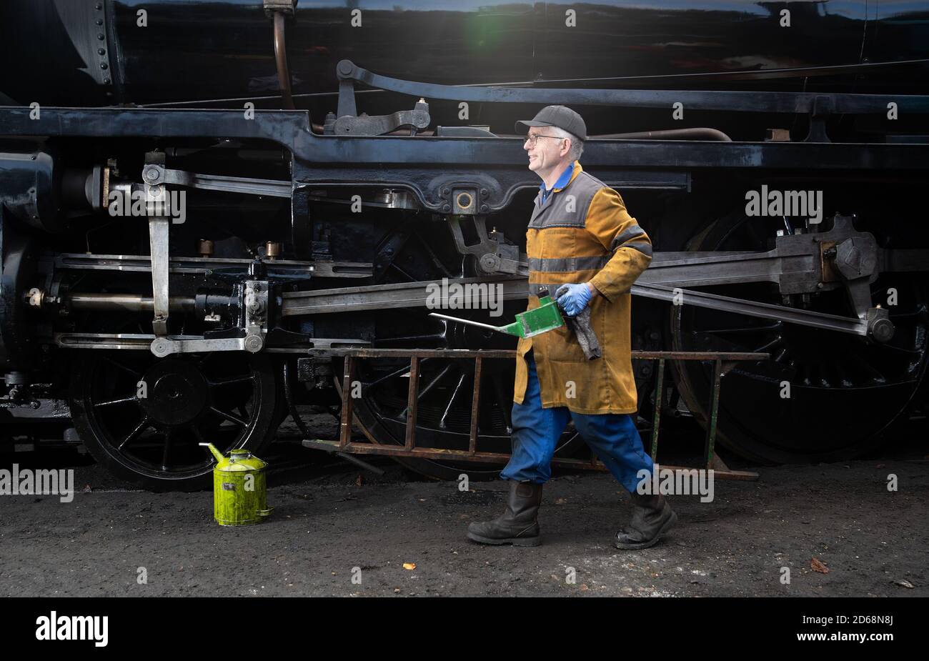 Un olio volontario sulla locomotiva a vapore classe S15 506 presso la stazione di Rotley, prima del gala a vapore d'autunno di questo fine settimana sulla linea di servizio di guardia della Mid Hants Railway. Foto Stock