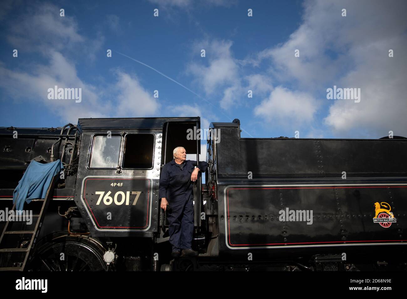 Driver Dave Pallett, Che si è offerto volontariamente sulla Mid Hants Railway per oltre 25 anni, guarda fuori dal taxi della British Railways Standard Class 4MT locomotiva a vapore 76017 come egli pone per una fotografia alla stazione di Rotley, in vista di questo weekend di autunno a vapore Gala sulla Mid Hants Railway's Watercress Line. Foto Stock