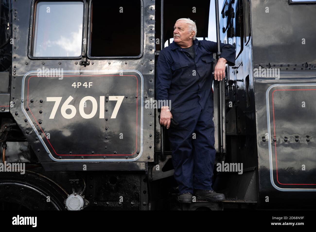 Il driver Dave Pallett, che si è offerto volontariamente sulla Mid Hants Railway per oltre 25 anni, guarda fuori dalla British Railways Standard Class 4MT locomotiva a vapore 76017, mentre si pone per una fotografia alla stazione di Rotley, in vista di questo fine settimana di Autumn Steam Gala sulla Mid Hants Railway's Watercress Line. Foto Stock