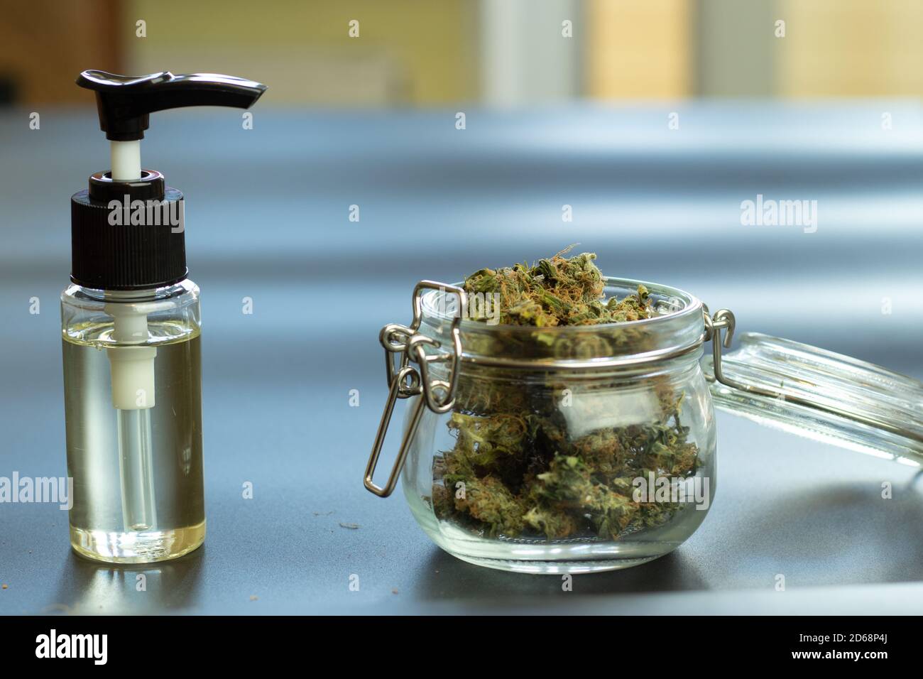 Bottiglia di olio cannabidiolo CBD e boccioli di cannabis in vaso su sfondo sfocato con spazio di copia. Illustrazione del negozio di commercio al dettaglio di marijuana Foto Stock