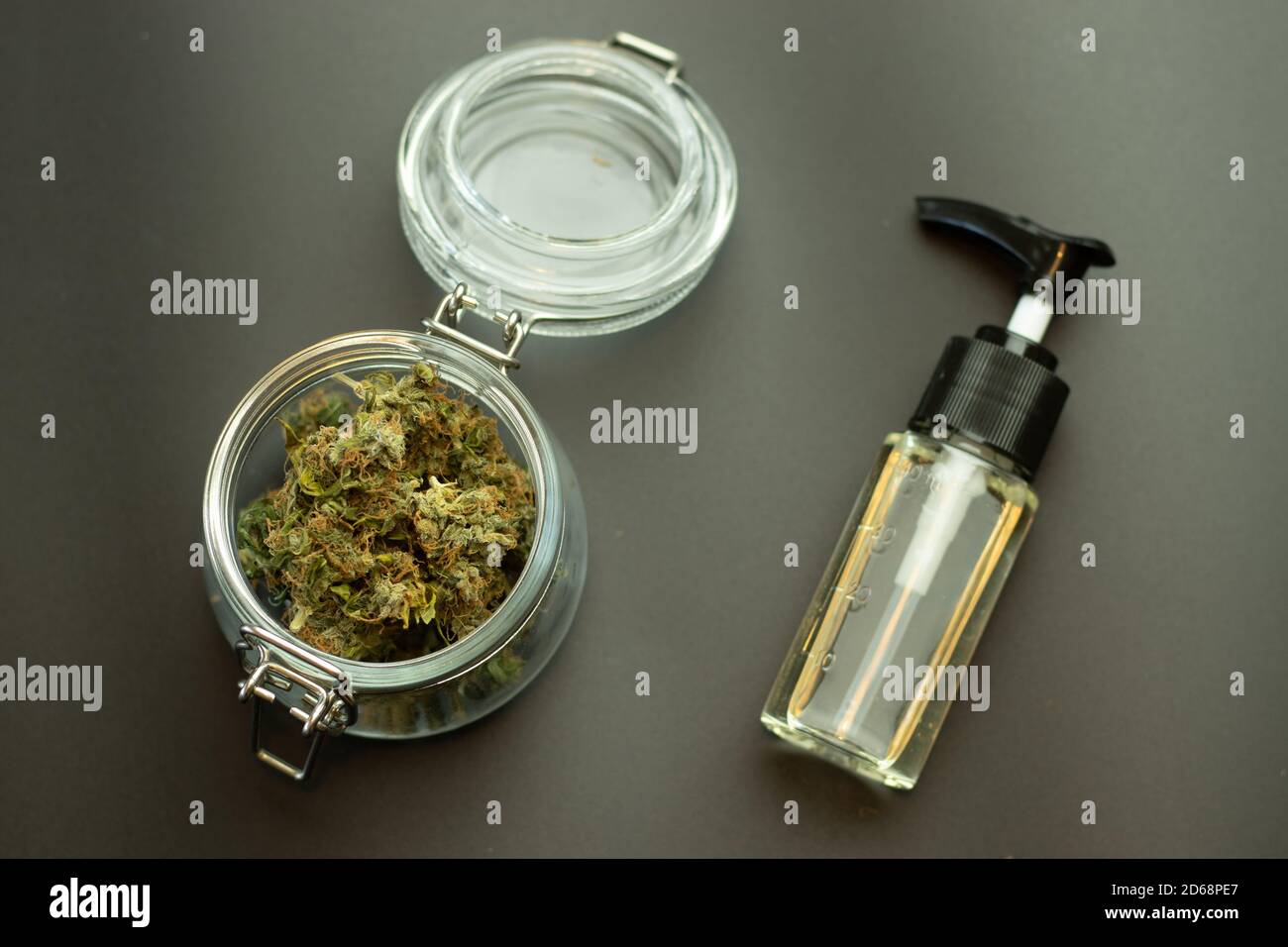 Olio di erbe CBD con germogli di cannabis in vaso di vetro vista dall'alto. Marijuana su sfondo nero. Concetto di industria di affari di erbaccia. Cannabidiolo medico e. Foto Stock