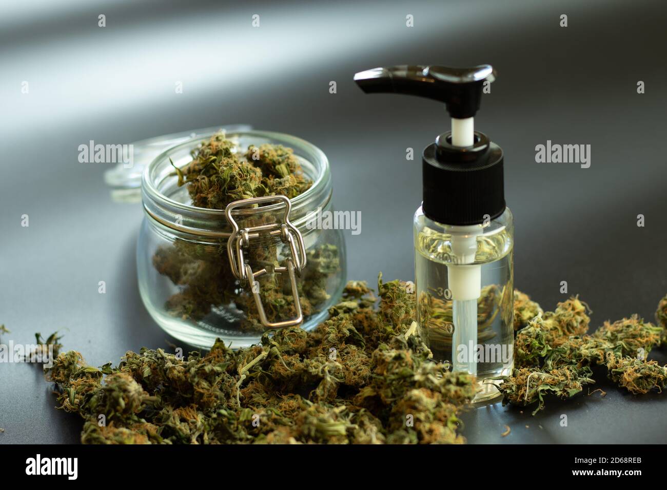 Olio CBD con boccioli di marijuana su sfondo nero. THC uso medico, concetto di set di cannabis al dettaglio Foto Stock