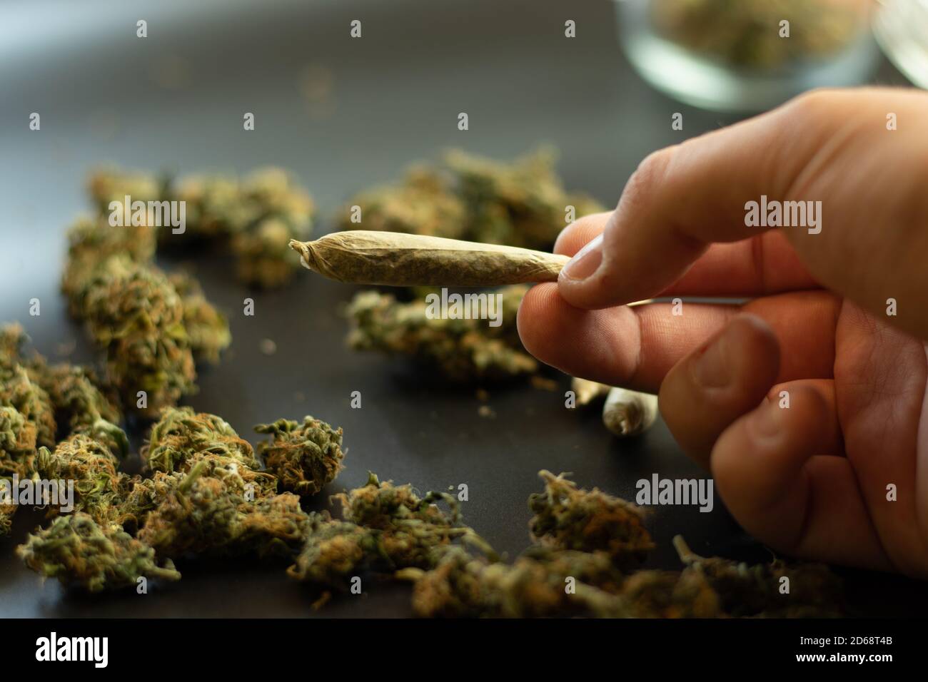 Uomo che tiene in mano la marijuana comune, cannabis su sfondo sfocato con spazio di copia. Fumo erbacce mediche Foto Stock