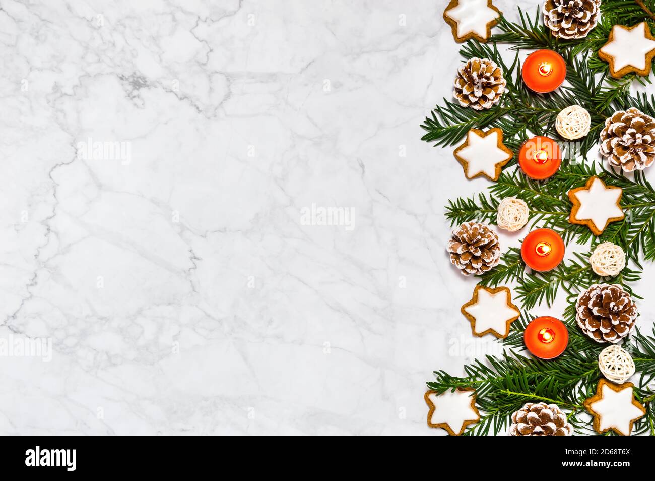 Decorazione dell'avvento con quattro candele brucianti, rami di conifere, coni di pino, biscotti alla cannella stella su sfondo di marmo. Biglietto d'auguri, spazio per la copia Foto Stock