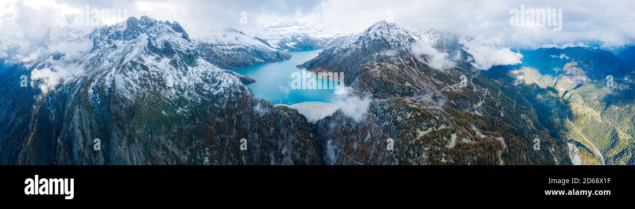 Panorama di Arch Dam e lago artificiale in neve coperta Alpi svizzere montagne per produrre energia rinnovabile da idroelettricità, idroelettricità sostenibile Foto Stock