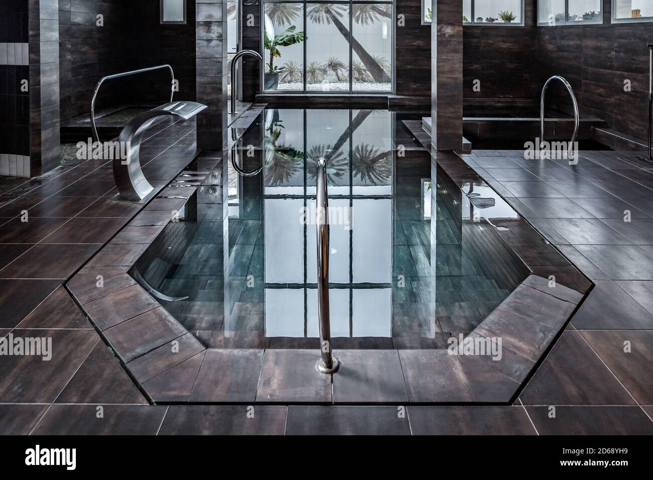 Piscina con acqua pulita trasparente e piscina piastrellata situata all'interno salone spa contemporaneo Foto Stock