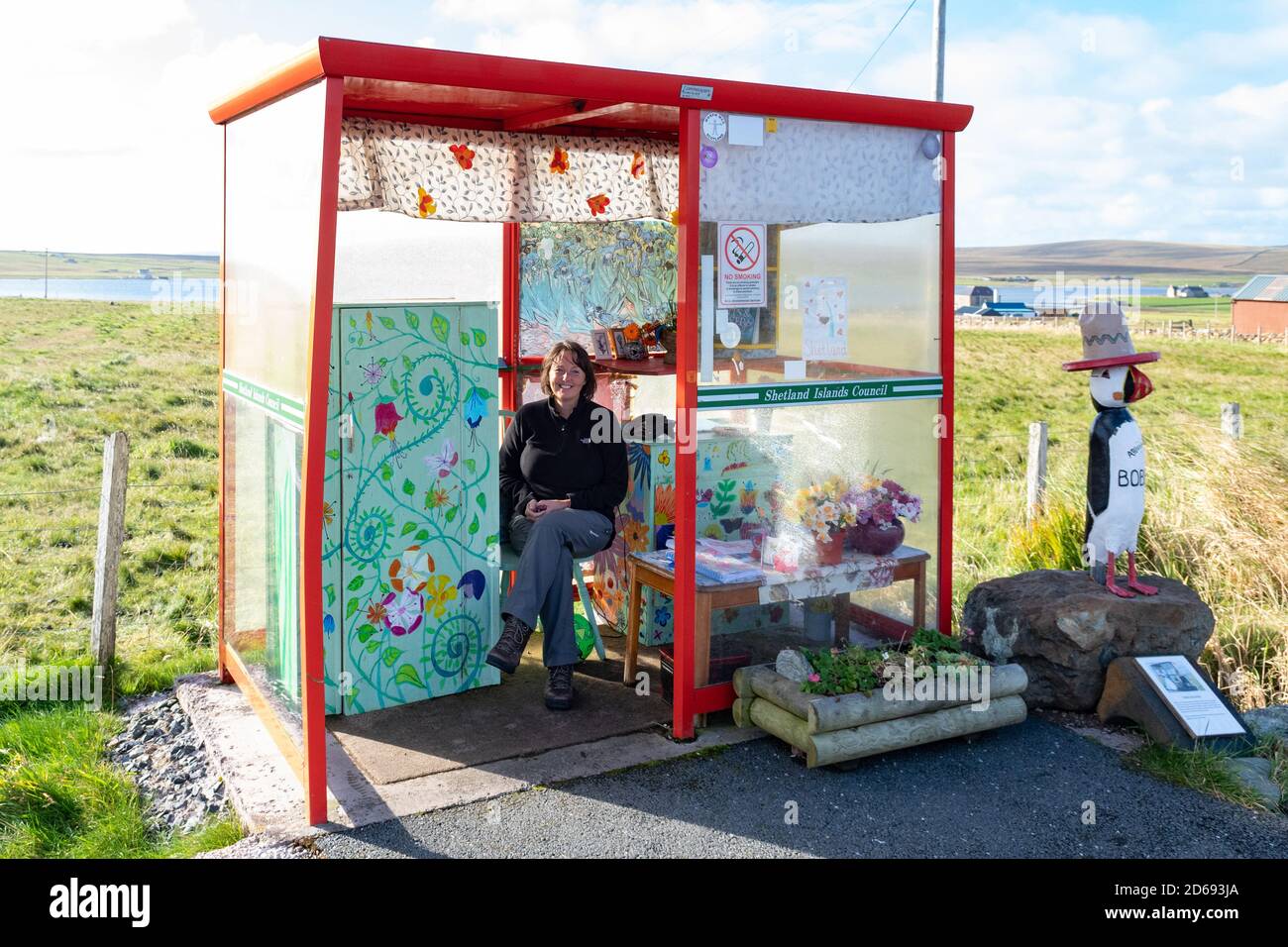 Bobby's Bus Shelter - turista seduto all'interno della bizzarra attrazione turistica, Unst, Shetland, Scozia, Regno Unito Foto Stock