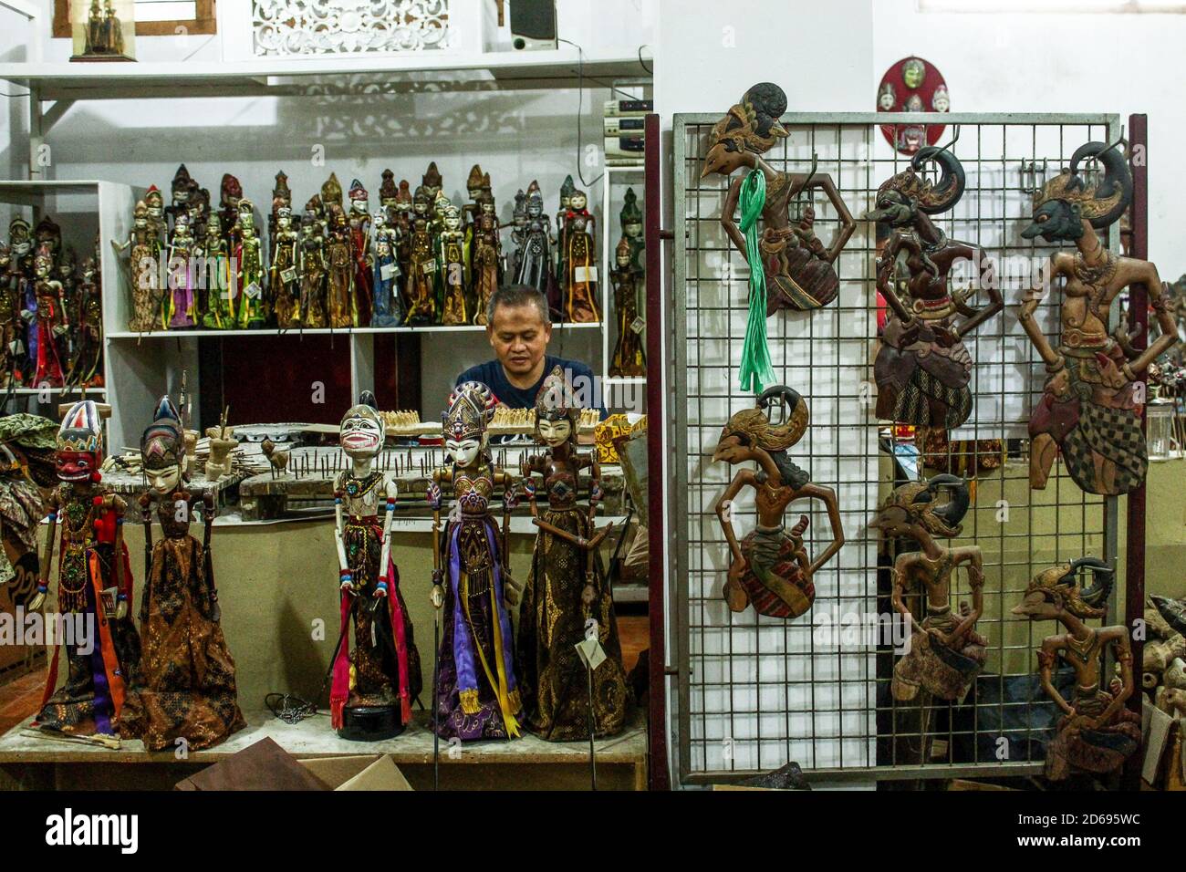 Un artigiano che dipinge marionette nella Galleria Cupuumanik. Cupupanik Puppets Gallery, fondata nel 1970, ha esportato burattini di varie dimensioni e forme per souvenir, collezioni, o spettacoli in vari paesi come il Belgio, l'America, l'Inghilterra, ecc. in mezzo alla pandemia di Covid-19, ora sopravvivono sulla vendita di mercato online. I prezzi medi dei burattini in questa galleria variano da 10,000 IDR a 1000,000 IDR secondo la taglia. Foto Stock