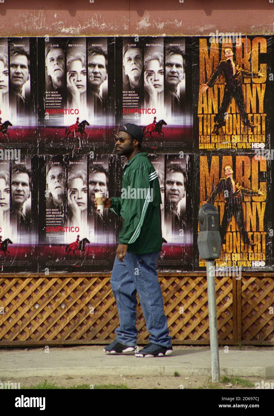 L'uomo passa accanto ai poster dei film su Windward Avenue, Venice Beach, Los Angeles, California, USA. Fotografia cinematografica, circa 2000 Foto Stock