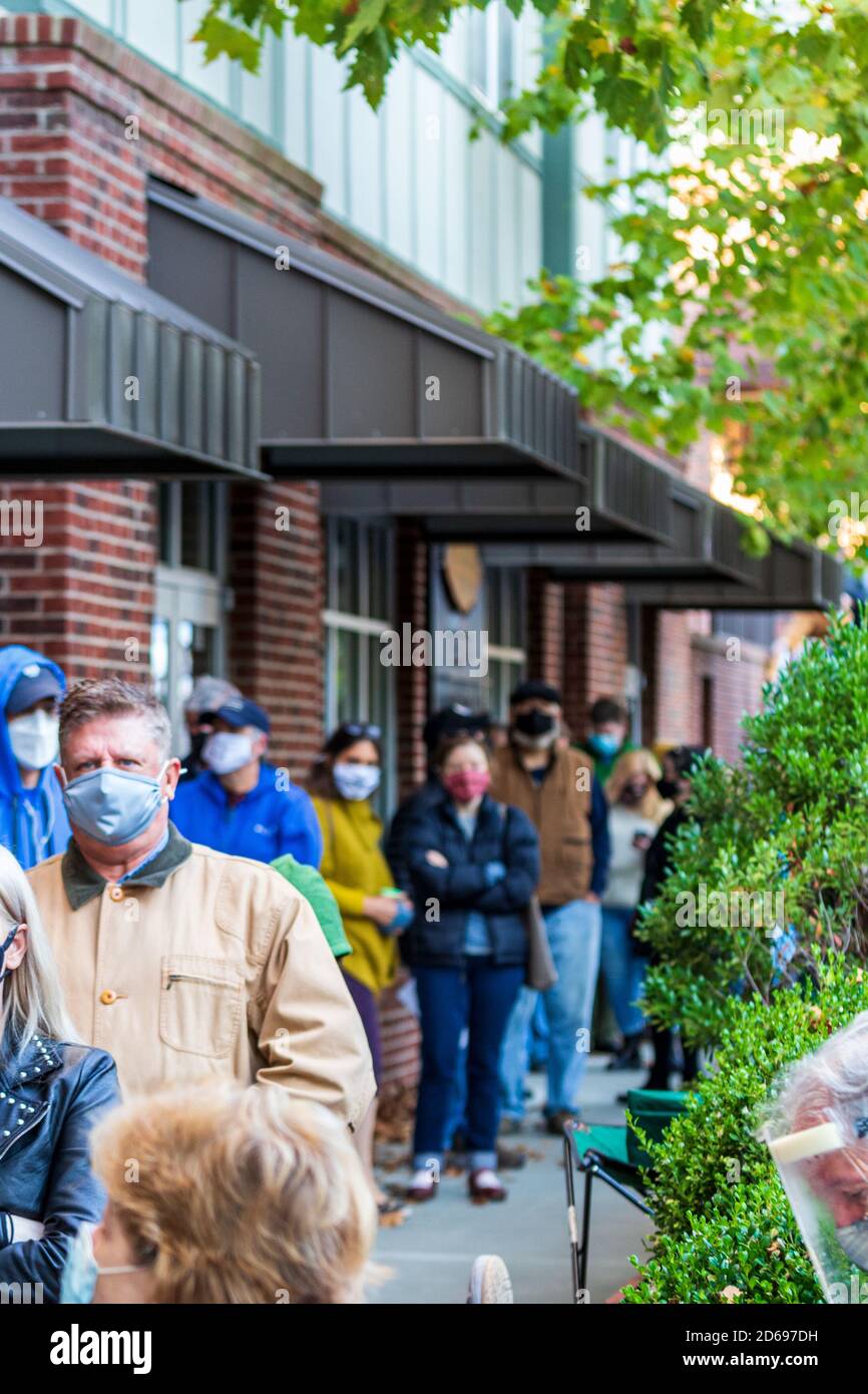 Asheville, North Carolina, Stati Uniti. 15 Ott 2020. A mezz'ora dall'apertura dei sondaggi nel piccolo Reynolds Village, gli elettori aspettano in fila tre blocchi di lunghezza, il primo giorno delle prime votazioni durante le elezioni generali nello stato della Carolina del Nord. Credit: Gloria Good/Alamy Live News Foto Stock