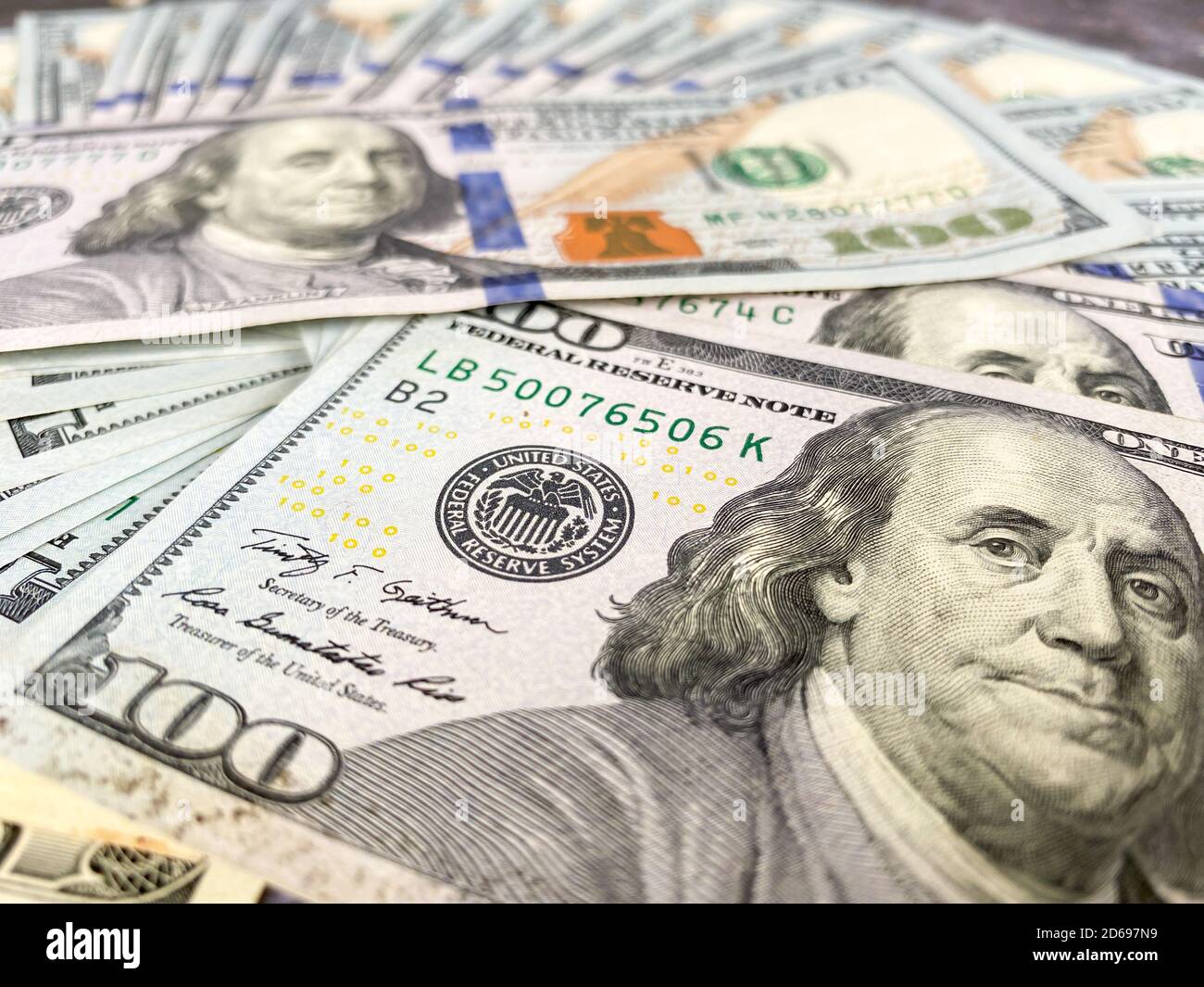 Bolletta da 100 dollari e ritratto di Benjamin Franklin sulla banconota USA. Primo piano di un centinaio di dollari bollette sul tavolo. Foto Stock