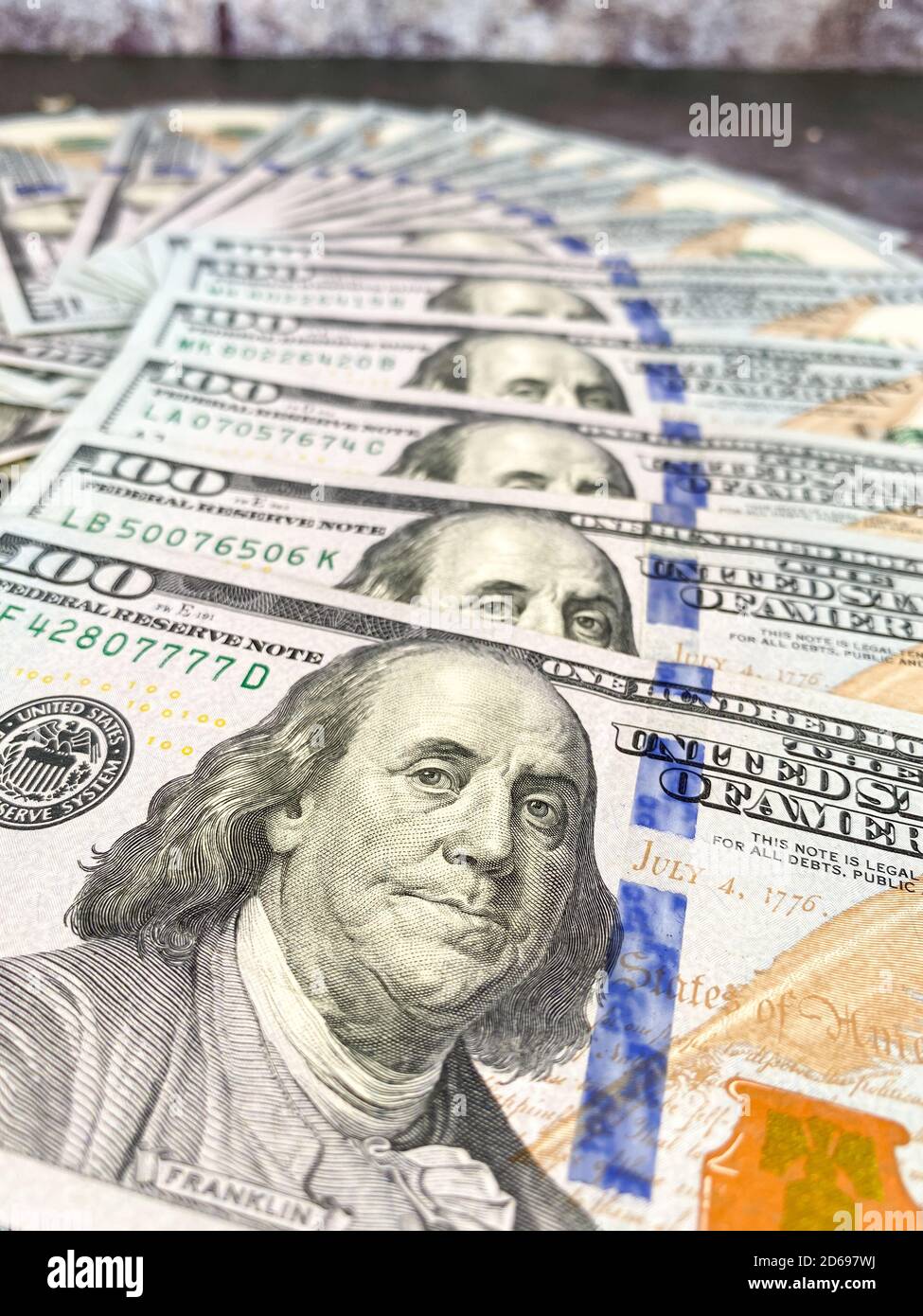 Bolletta da 100 dollari e ritratto di Benjamin Franklin sulla banconota USA. Primo piano di un centinaio di dollari bollette sul tavolo. Foto Stock