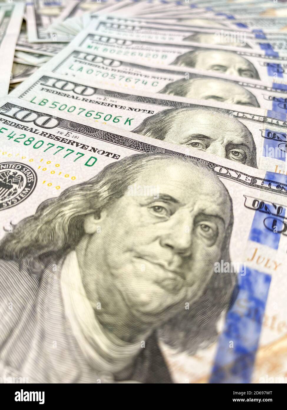 Bolletta da 100 dollari e ritratto di Benjamin Franklin sulla banconota USA. Primo piano di un centinaio di dollari bollette sul tavolo. Foto Stock