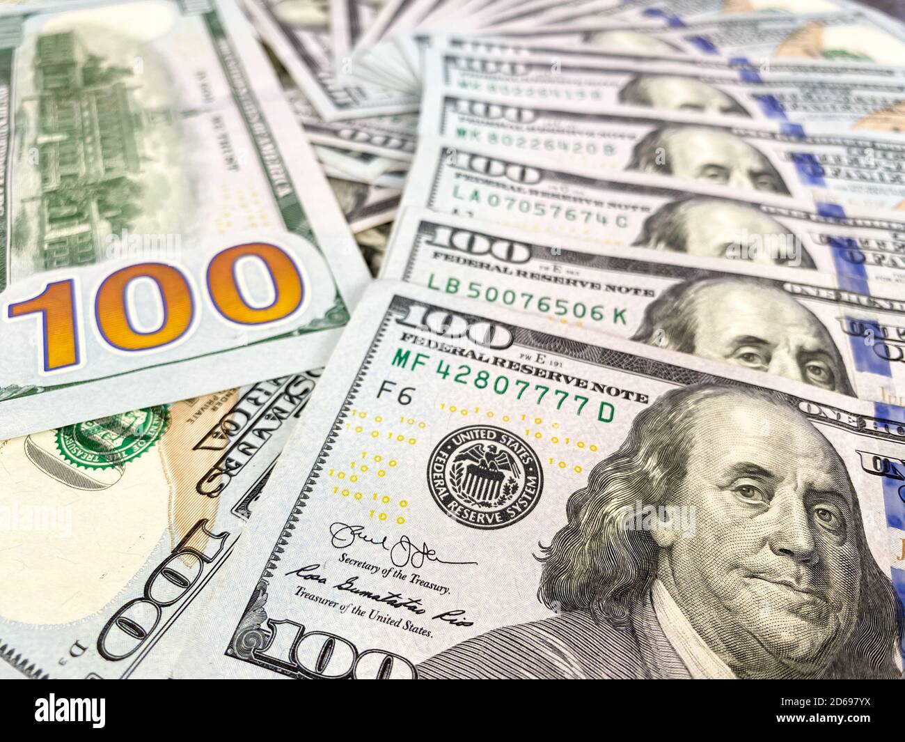 Bolletta da 100 dollari e ritratto di Benjamin Franklin sulla banconota USA. Primo piano di un centinaio di dollari bollette sul tavolo. Foto Stock