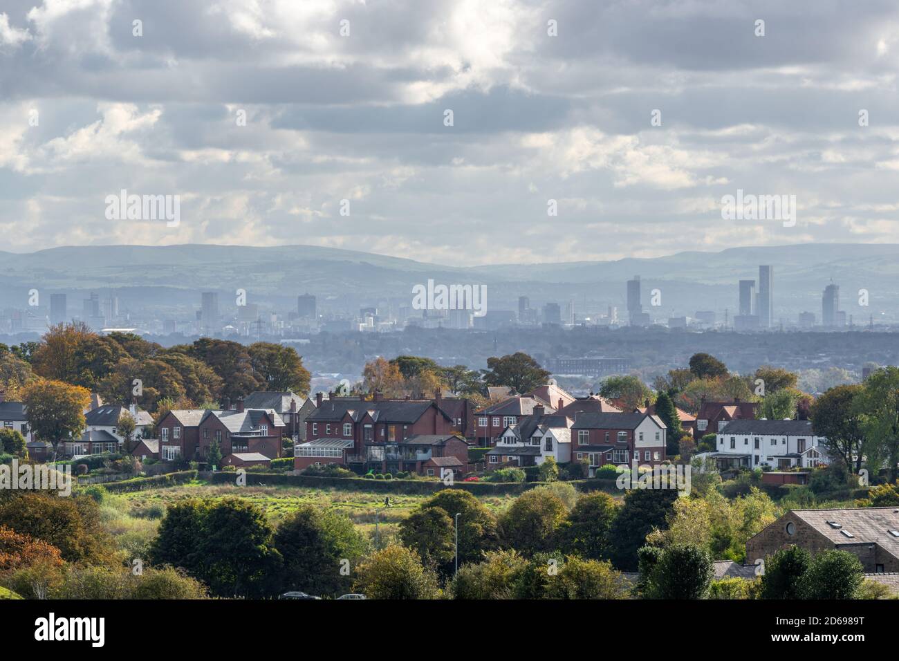 Lo skyline della città di Manchester visto dal nord-ovest con le case e le strade suburbane in primo piano, Inghilterra Regno Unito Foto Stock