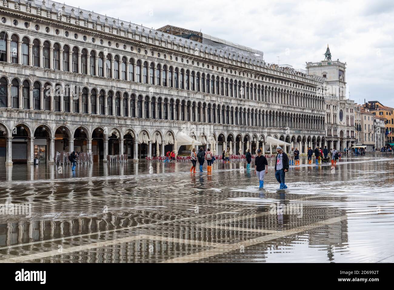 Acque alte - acqua alta che causa inondazioni in Piazza San Marco - turisti che si riversano attraverso l'acqua in abitazioni. Venezia, Italia durante la pandemia di Covid-19. Foto Stock