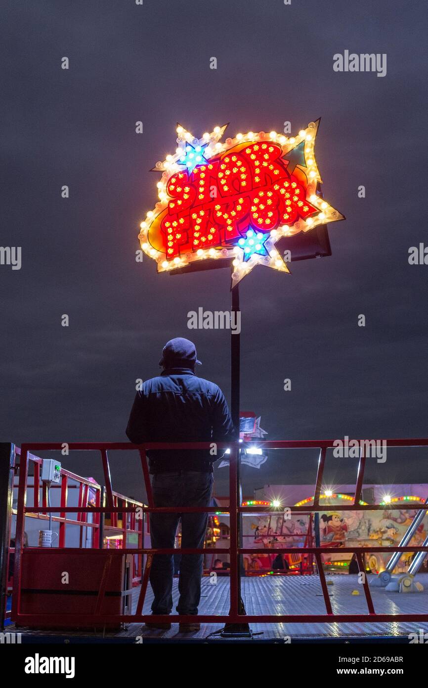 Il proprietario dello stallo di Star Flyer ad una fiera itinerante a Redhill Common a Bournemouth in primavera comincia ad essere occupato mentre il sole scende e le luci luminose attraggono i visitatori. 08 aprile 2016. Foto: Neil Turner Foto Stock