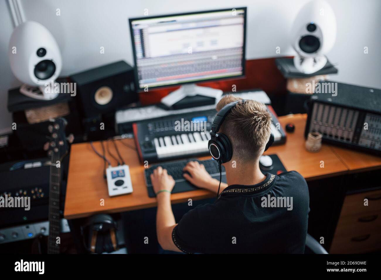 Tecnico del suono nelle cuffie che lavora e mixa musica in interni il monolocale Foto Stock
