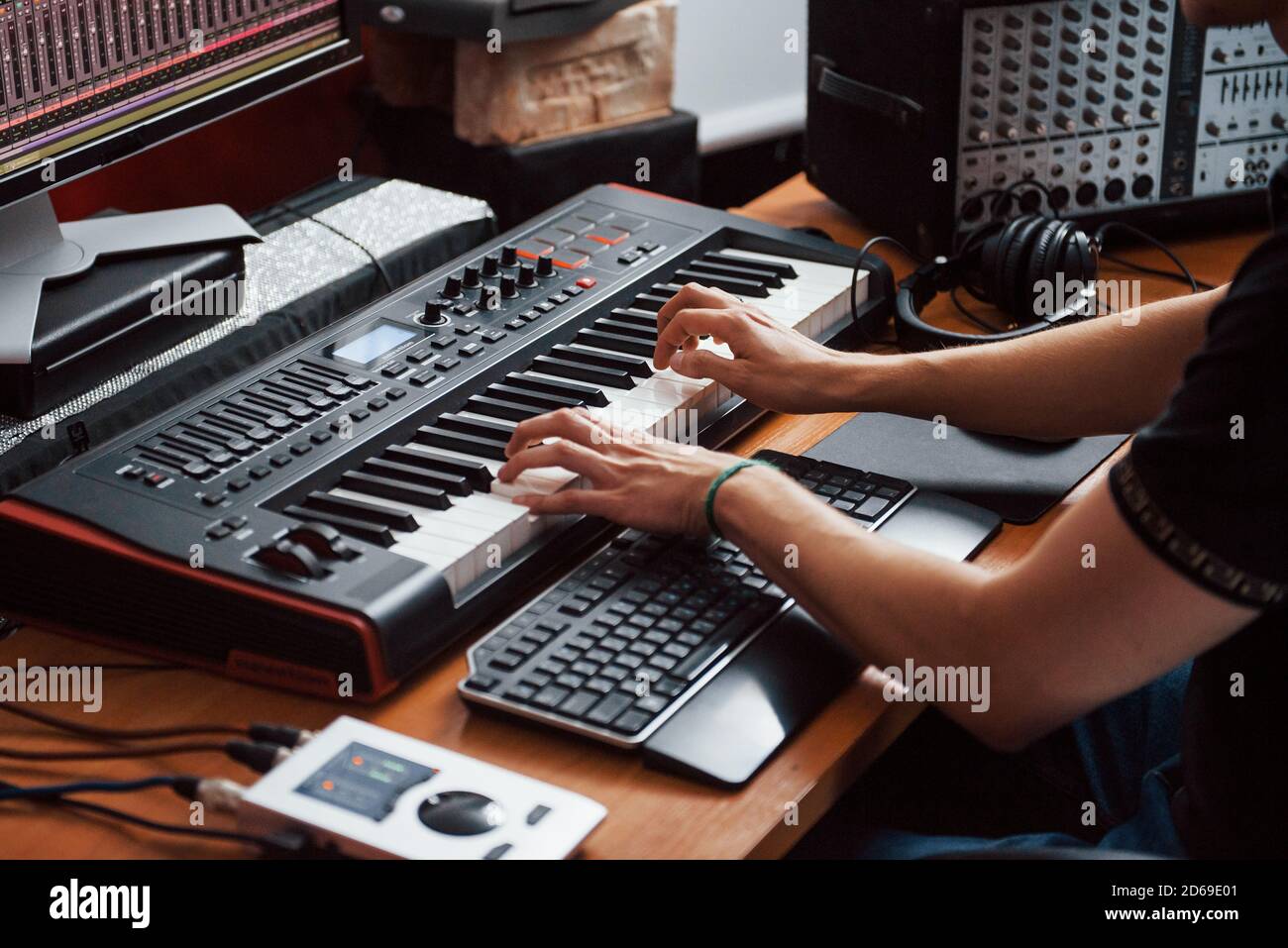 Riproduzione della tastiera midi. Ingegnere del suono che lavora e mixa musica all'interno dello studio Foto Stock