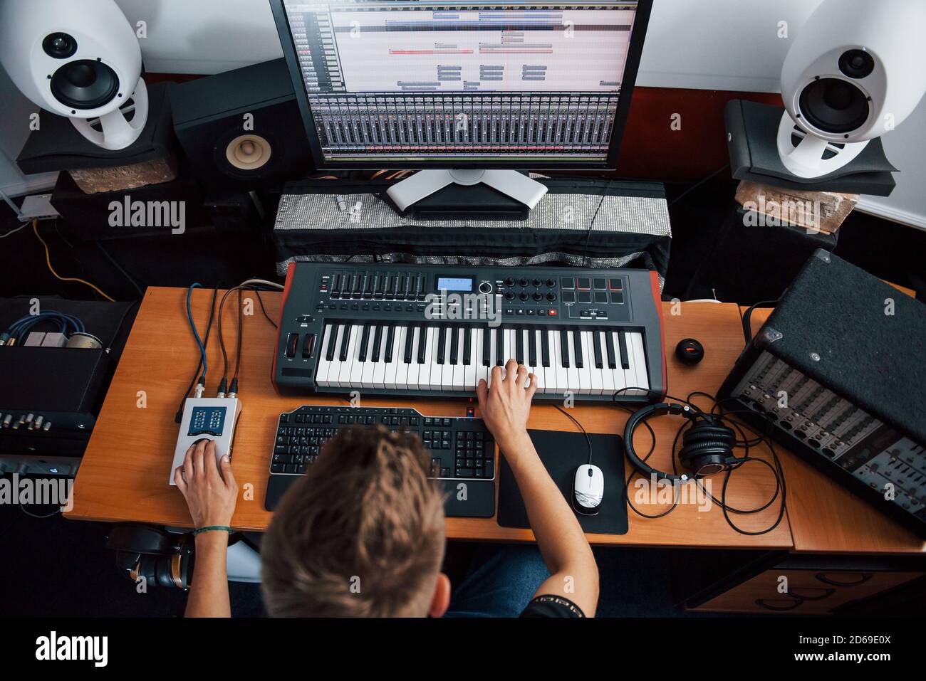 Vista dall'alto. Ingegnere del suono che lavora e mixa musica all'interno dello studio Foto Stock
