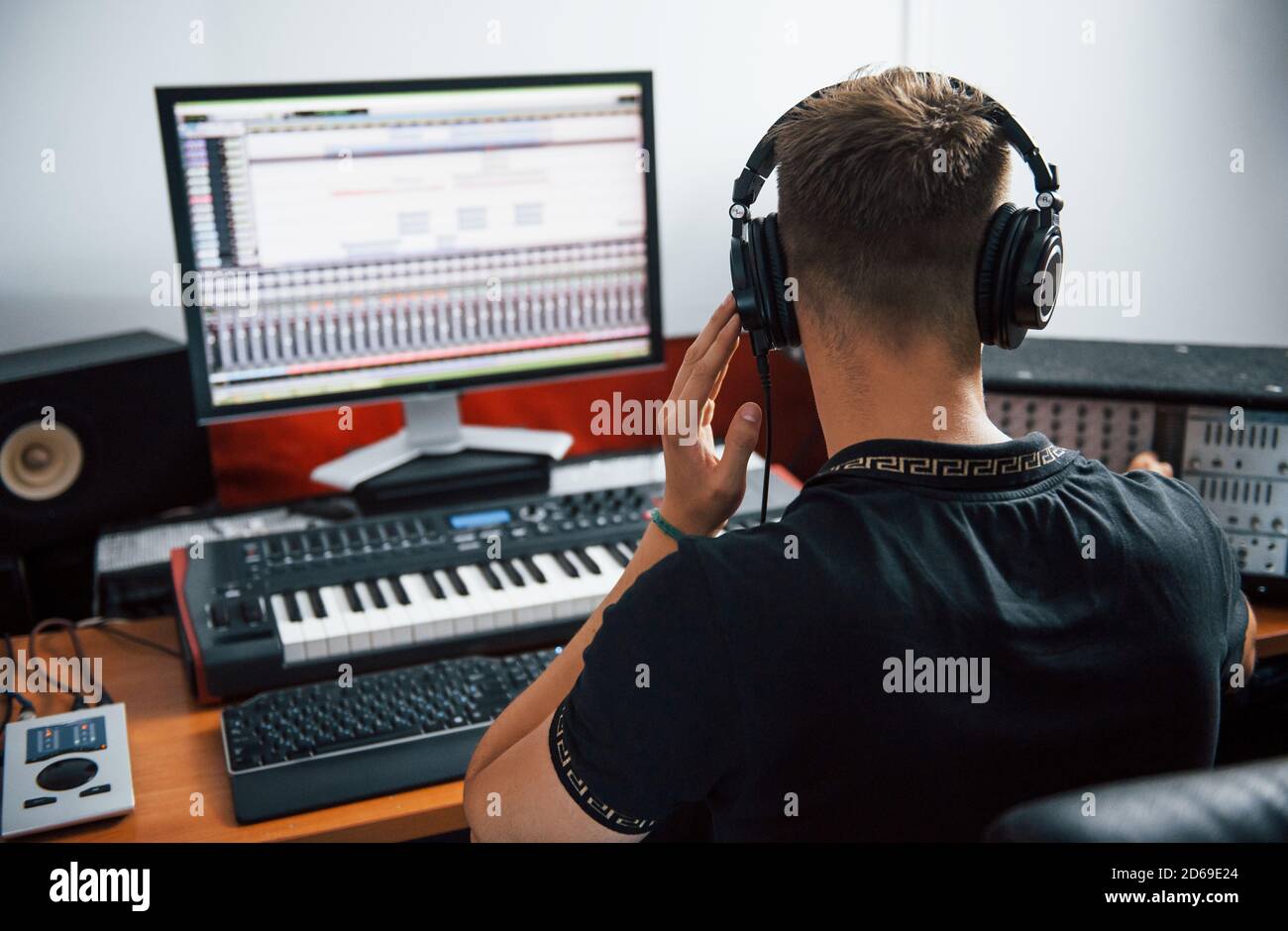 Tecnico del suono nelle cuffie che lavora e mixa musica in interni il monolocale Foto Stock