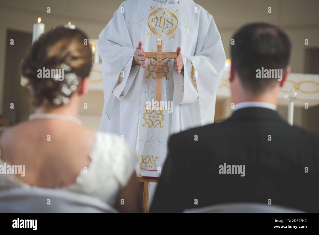 Sposa e sposo in piedi davanti al sacerdote a. l'altare Foto Stock