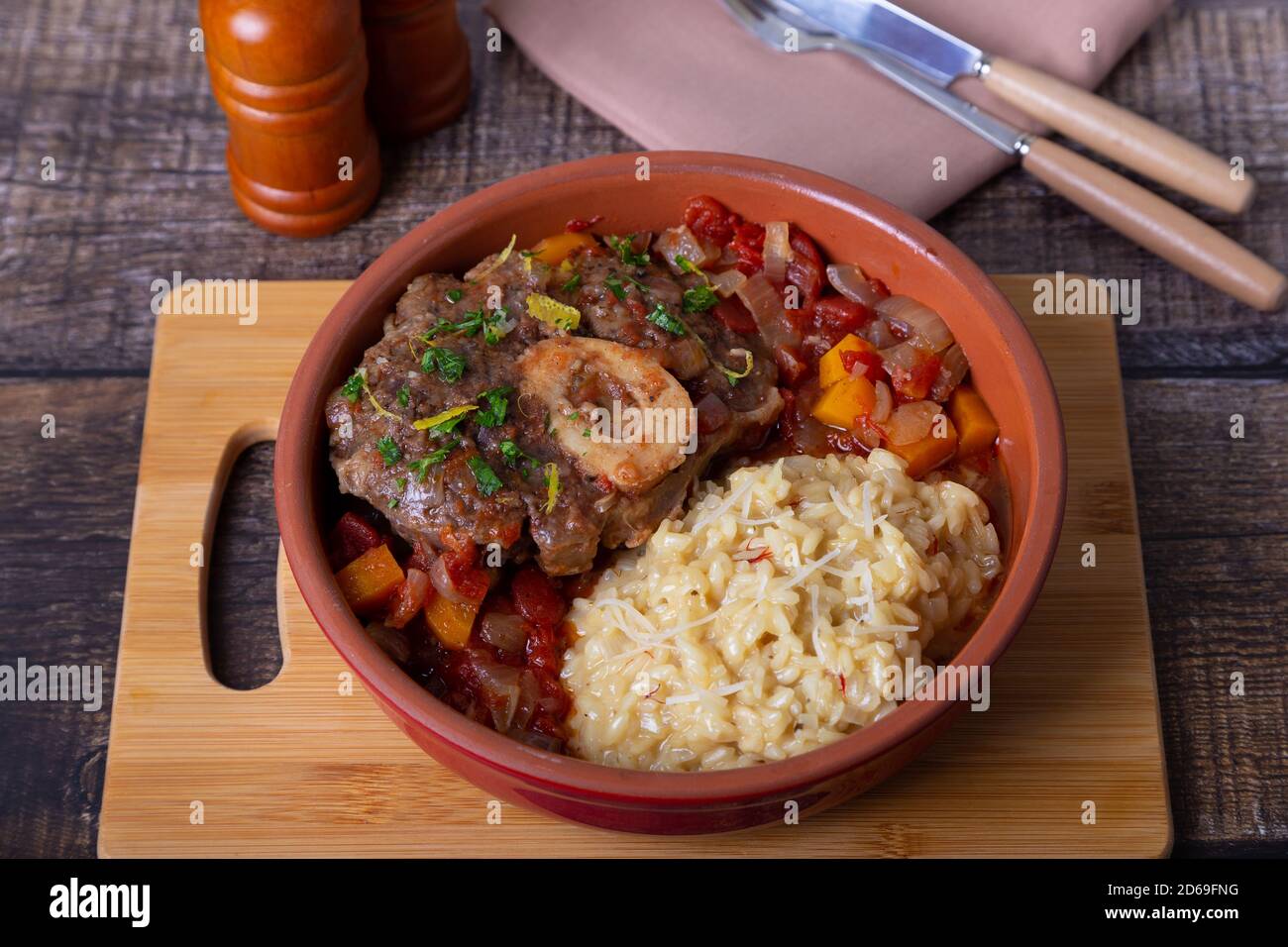 Ossobuco. Scanchi di vitello (manzo) con risotto allo zafferano in milanese, gremolata e salsa. Piatto tradizionale italiano. Primo piano. Foto Stock