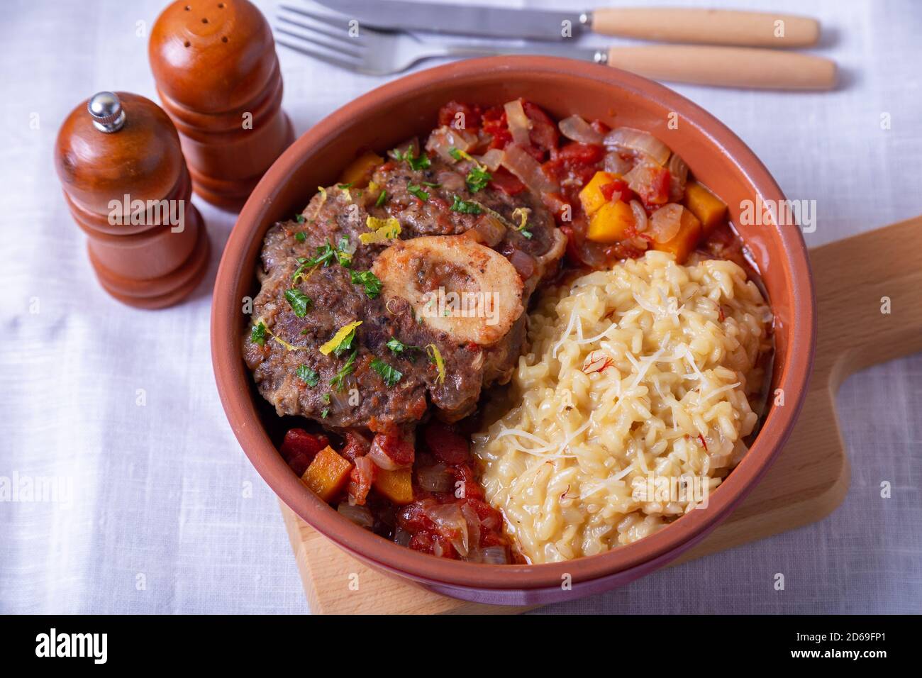 Ossobuco. Scanchi di vitello (manzo) con risotto allo zafferano in milanese, gremolata e salsa. Piatto tradizionale italiano. Primo piano. Foto Stock