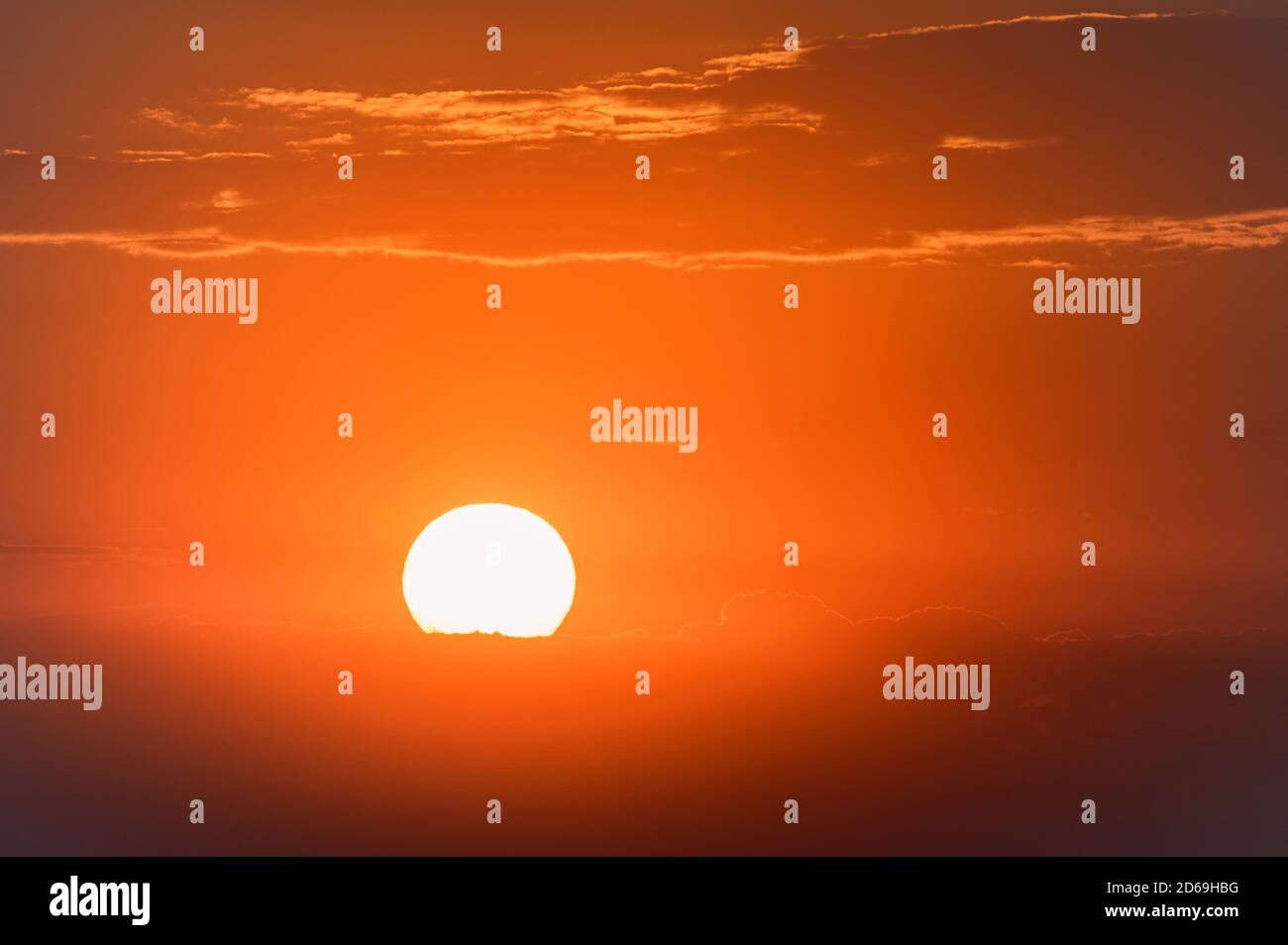 Cielo scenografico al tramonto con nuvole scure e sole rosso Foto Stock