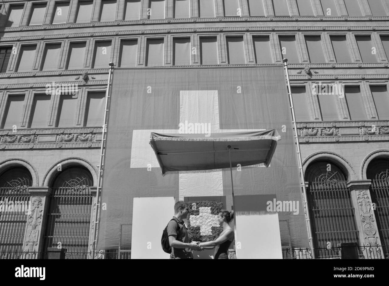 Un paio di amore nella parte anteriore del grande bandiera svizzera a tha banca nazionale alla giornata nazionale sulla Bürkliplatz nella cittã di Zurigo Foto Stock