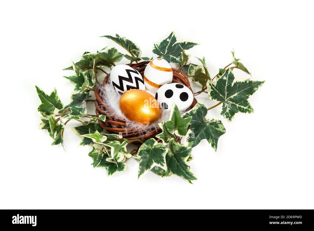Buona Pasqua. Uova dipinte in oro e nero in nido d'edera. Congratulazioni pasqua background. Isolato su sfondo bianco. Foto Stock