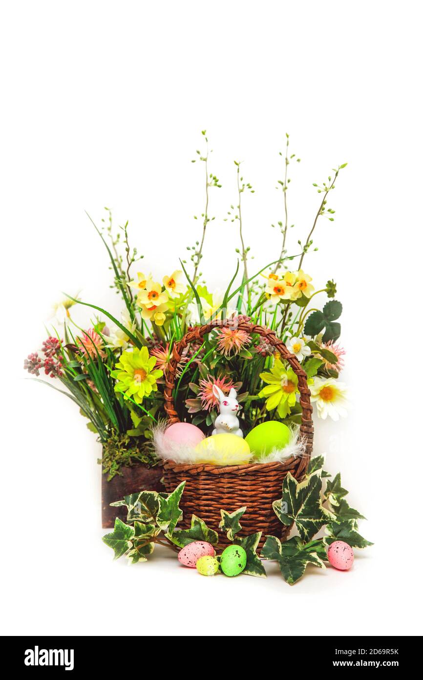 Buona Pasqua. Congratulazioni pasqua background. Uova di Pasqua colorate e fiori con un piccolo coniglietto bianco in cestino. Foto Stock