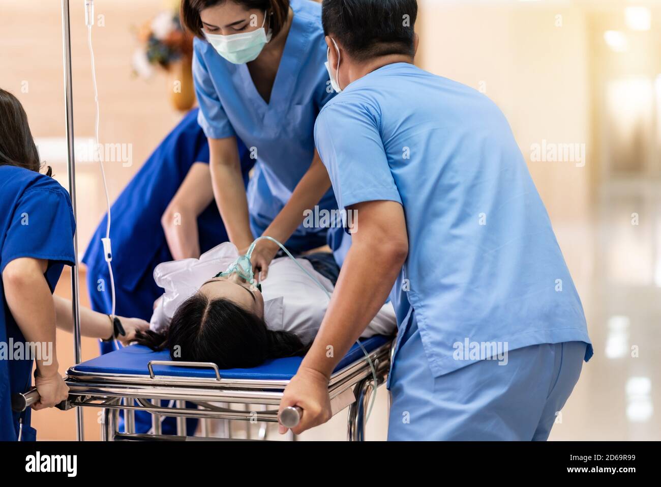 Il team medico esegue la rianimazione cardiopolmonare CPR per pazienti  gravemente feriti con maschera di ossigeno mentre si spinge il letto della  barella gurney nella sala operatoria Foto stock - Alamy