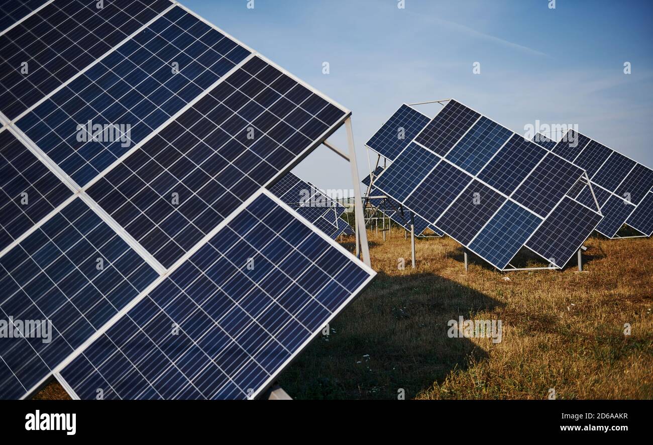 Campo con batterie solari al sole di giorno. Concezione dell'ecologia e del carburante Foto Stock