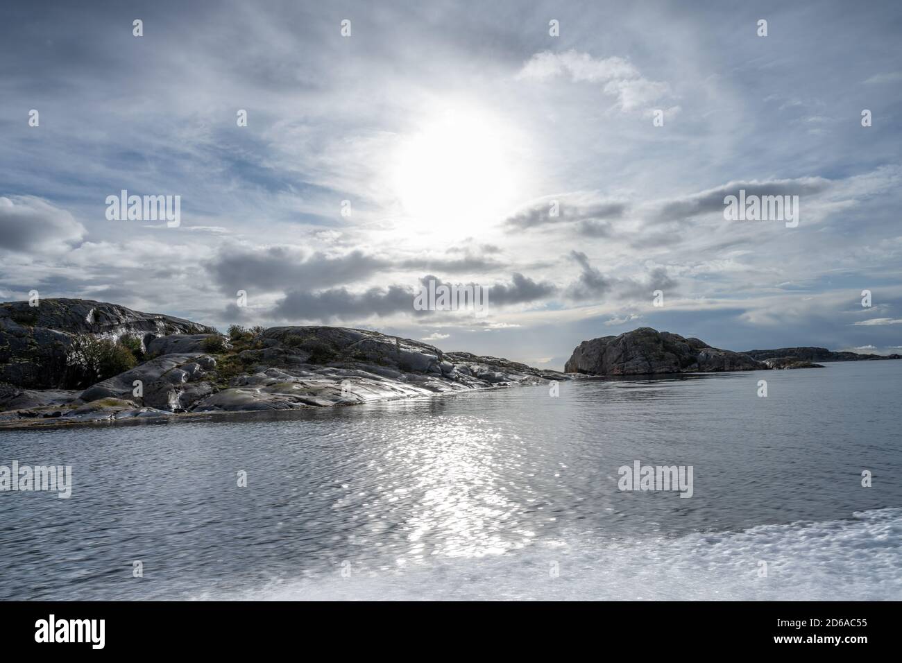 Foto retroilluminata di un tramonto dall'arcipelago delle Weather Island, il punto più occidentale della Svezia. Cielo blu e oceano blu Foto Stock