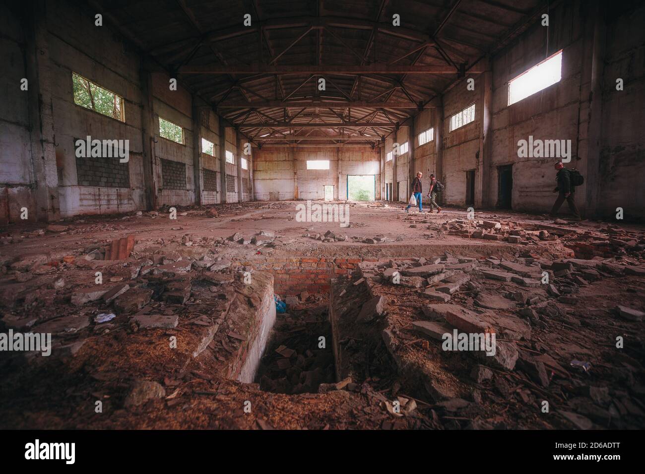Hangar abbandonato in rovina con tetto alto durante il giorno. All'interno dell'edificio abbandonato Foto Stock