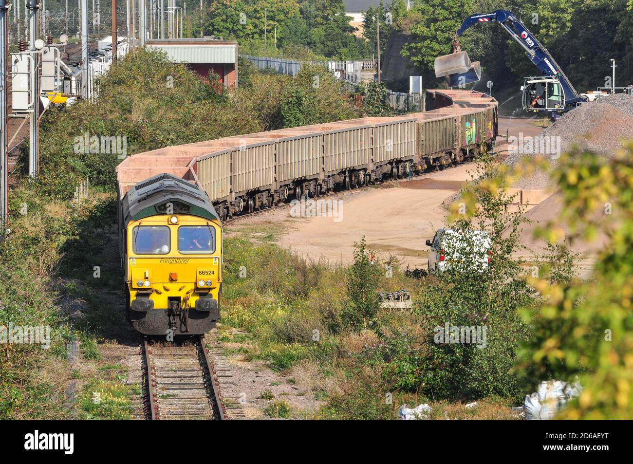 Classe 66 con treno di aggregati nel cantiere di Hitchin, Hertfordshire, Inghilterra, Regno Unito Foto Stock