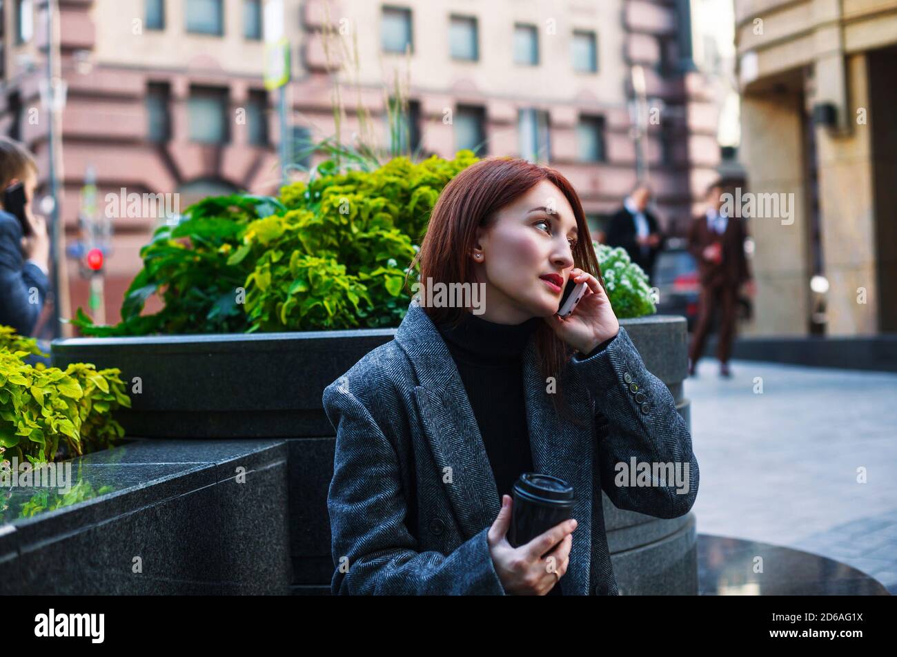 Donna di affari che parla su un telefono in una città del centro. Ritratto esterno femminile. Foto Stock