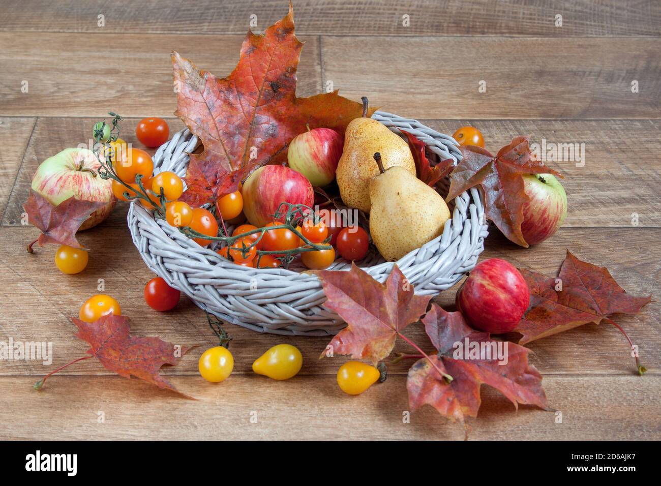 Autunno still life con frutti e foglie di autunno sono giacenti in un cesto di vimini. Doni della natura. Foto Stock