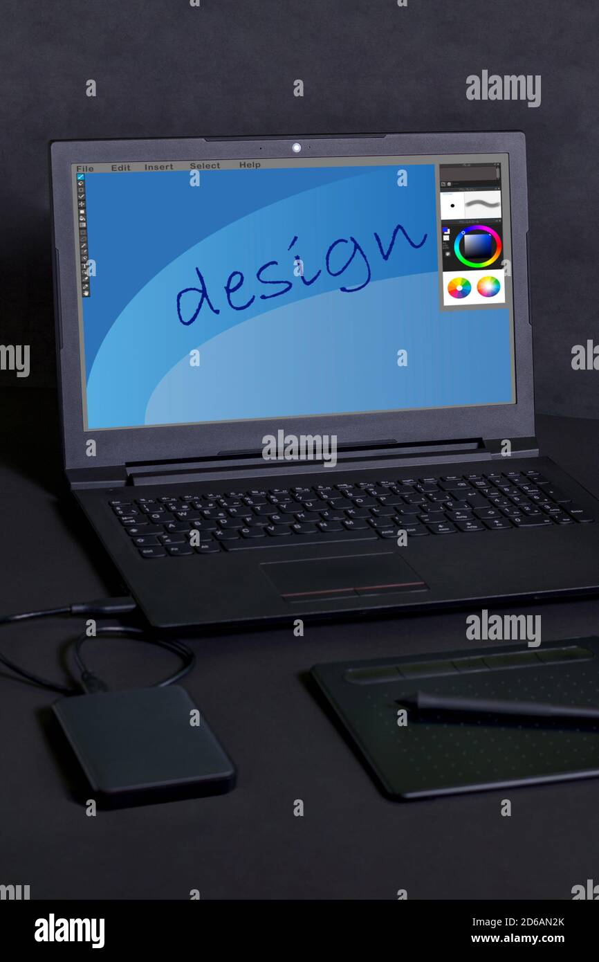 Tablet a penna, con un computer portatile e un disco rigido su sfondo nero Foto Stock