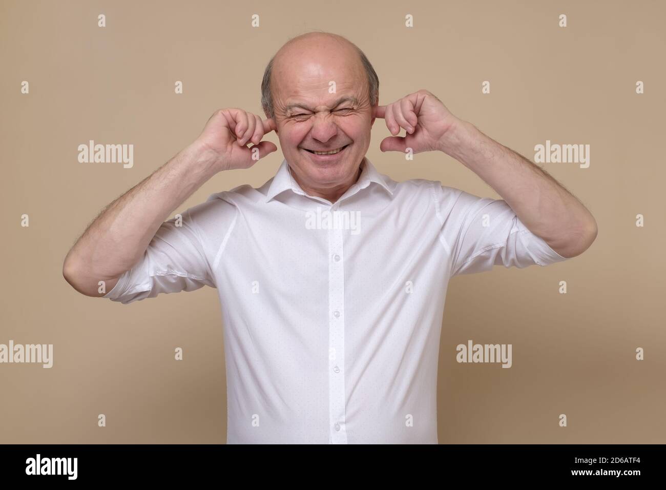 Uomo caucasico senior che copre le orecchie cercando di evitare di sentire spoiler. Foto Stock