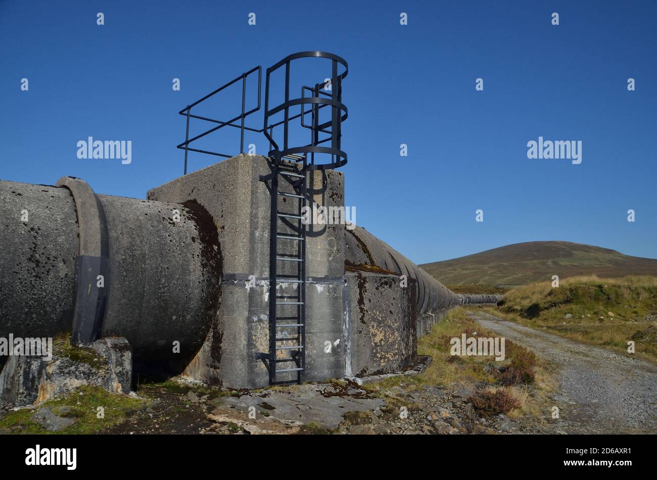 Una grande camera di ispezione e un blocco di spinta su un gasdotto di acqua di cemento, parte del sistema idrico Loch Shin nelle Highlands scozzesi, Regno Unito Foto Stock