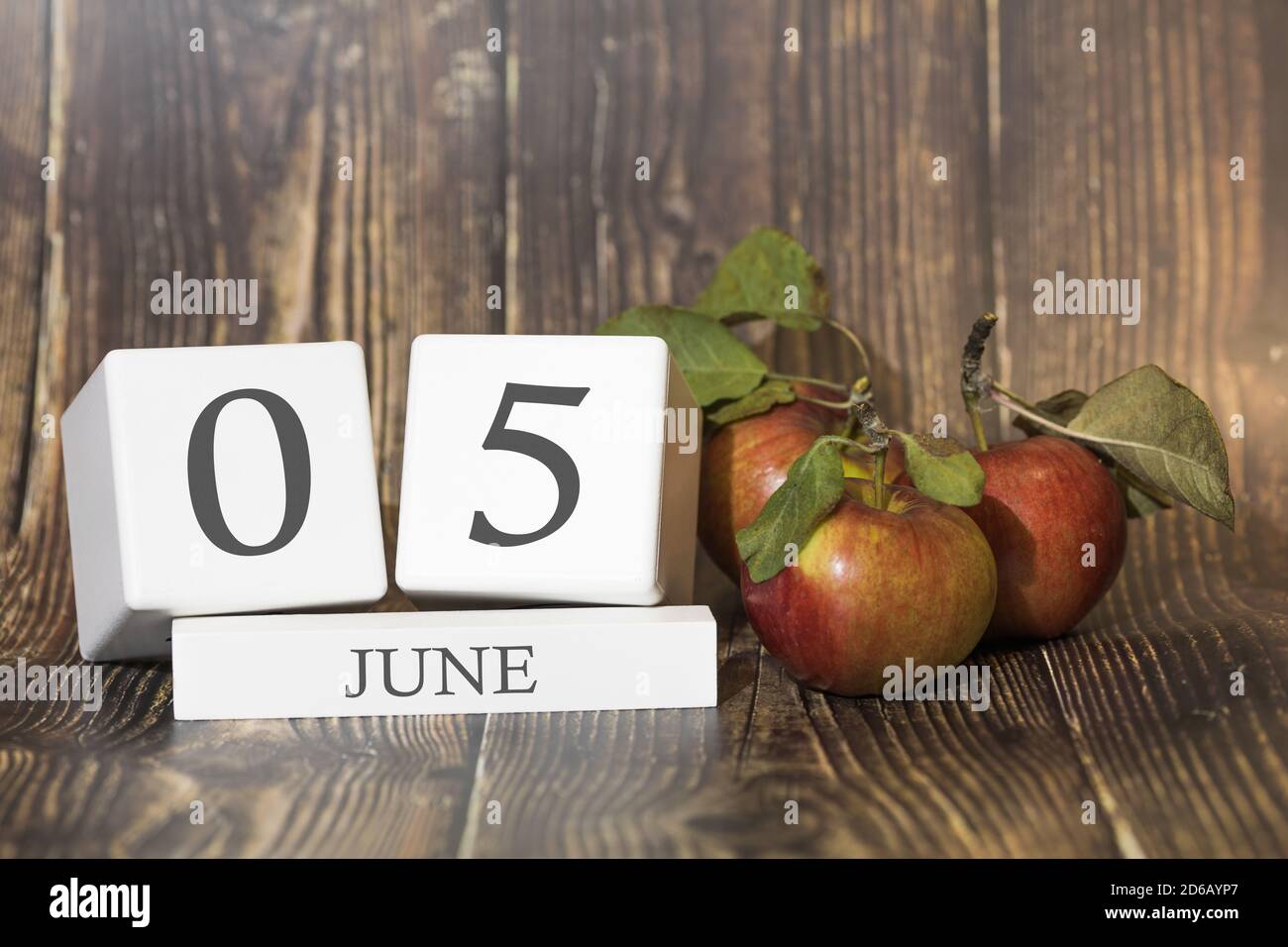 5 giugno. Giorno 05 del mese. Cubo di calendario su sfondo di legno con mele rosse, concetto di business e un evento importante. Stagione estiva. Foto Stock