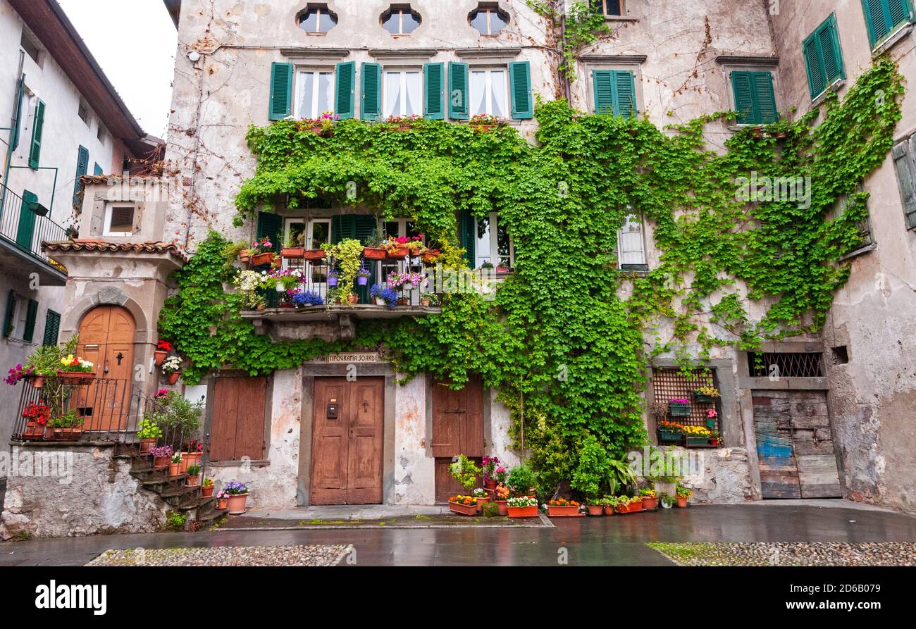 Bellissimo edificio coperto di edera a Pisogne, Lombardia, Italia sulle rive del Lago d'Iseo Foto Stock