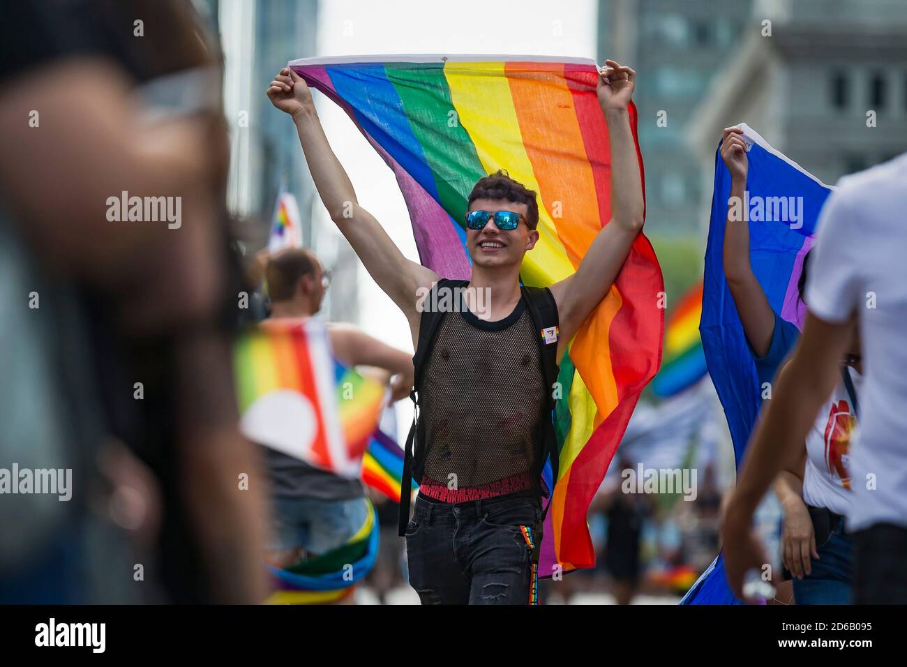 Un uomo ha una bandiera di Pride durante la Parata di Pride a Montreal, Quebec, Canada domenica 19 agosto 2018. Foto Stock