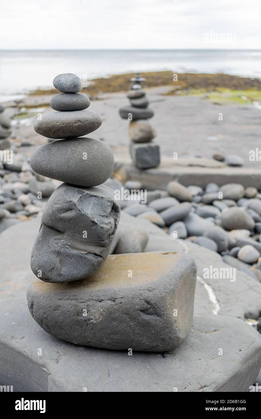 Rocce accatastate in una formazione still in piedi, ciottoli dalla spiaggia messi uno su un altro come hig possibile, gruppi di pietre in posizioni verticali Foto Stock
