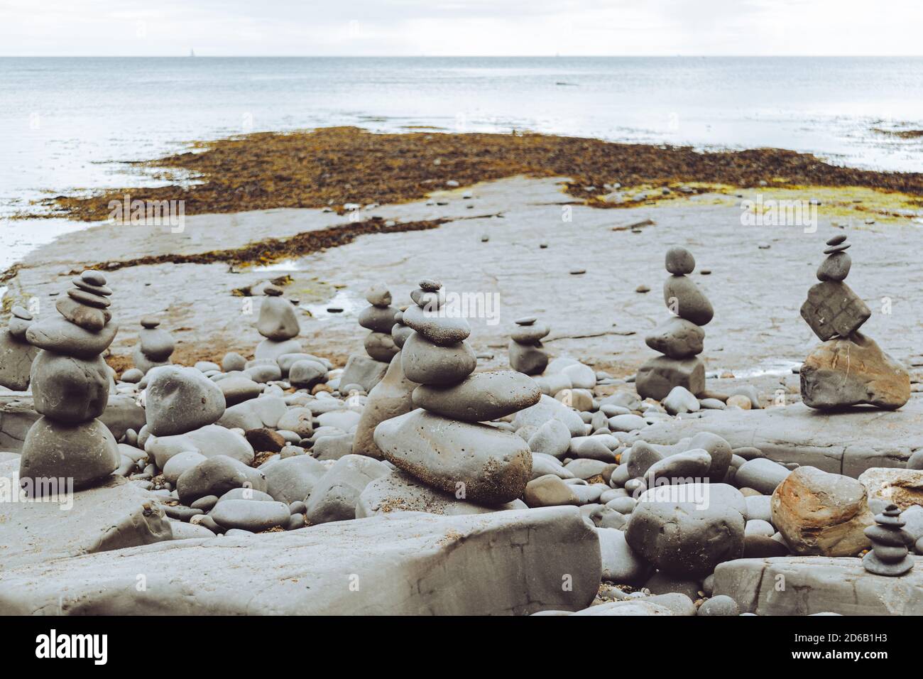 Rocce accatastate in una formazione still in piedi, ciottoli dalla spiaggia messi uno su un altro come hig possibile, gruppi di pietre in posizioni verticali Foto Stock