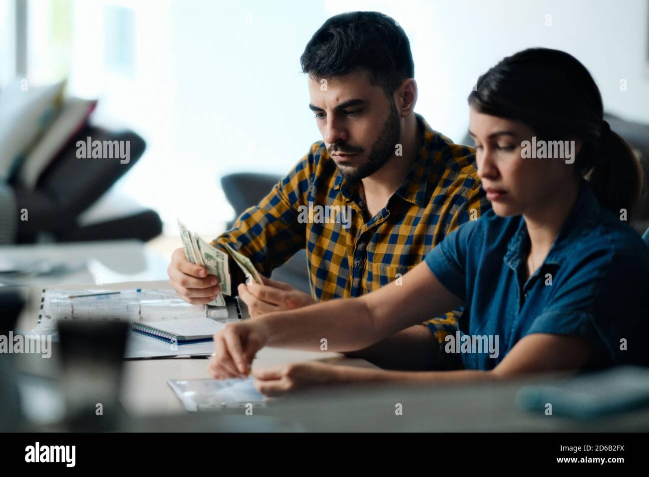 Coppia facendo bilancio domestico che conta i soldi per pagare le fatture Foto Stock