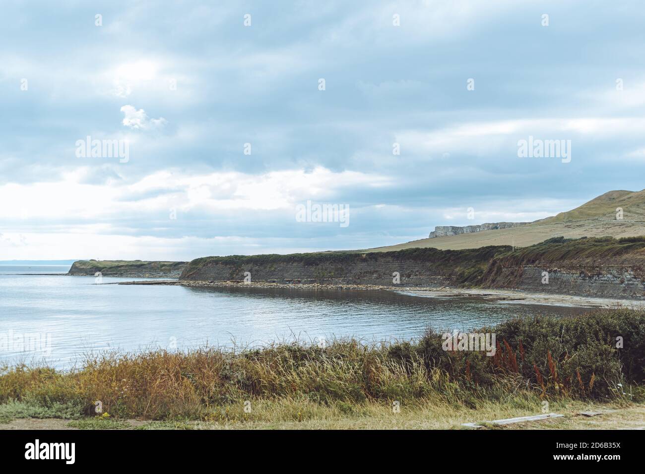 Vista di Kimmeridge Bay, Dorset UK, vista panoramica di calme acque oceaniche, drammatico cielo sovrastato Foto Stock